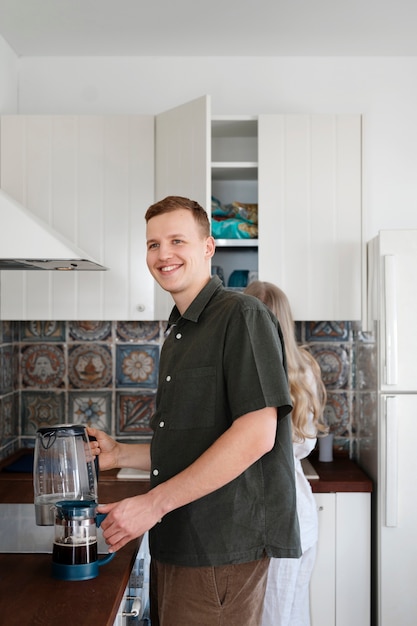 Free Photo medium shot smiley man with coffee pot