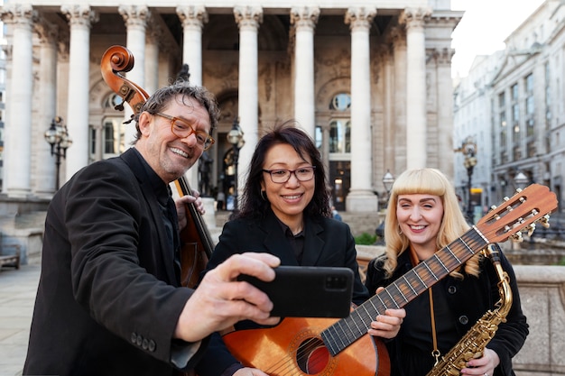 Free photo medium shot smiley musicians taking selfie