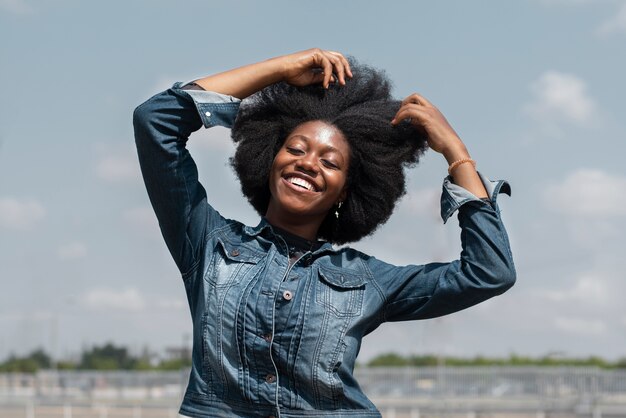 Medium shot smiley nigerian woman posing outside