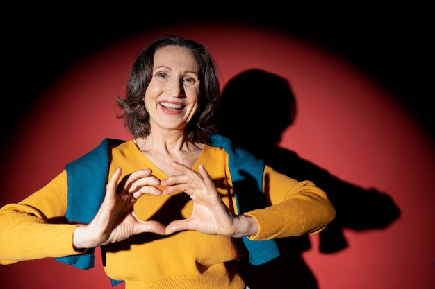 Medium shot smiley old woman posing in spotlight