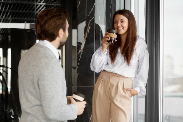 Free photo medium shot smiley people chatting at work