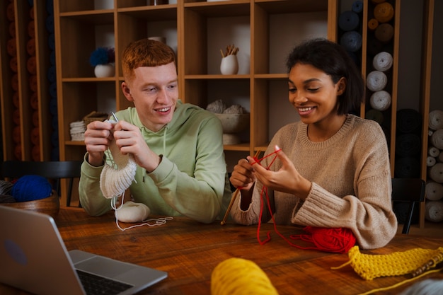 Medium shot smiley people knitting together