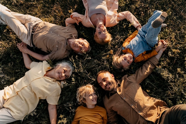 Free photo medium shot smiley people laying on grass