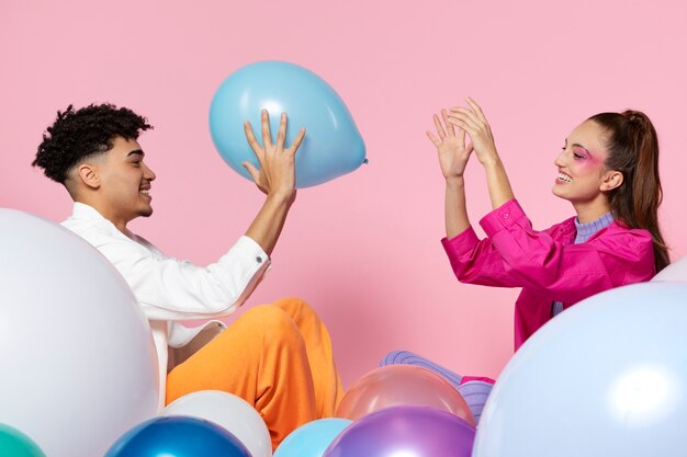 Medium shot smiley people playing with balloon