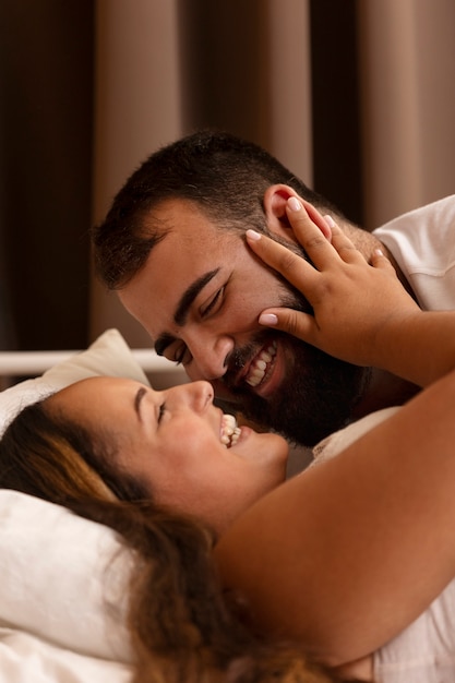 Free photo medium shot smiley romantic couple in bed