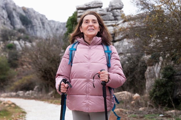 Medium shot smiley senior woman hiking