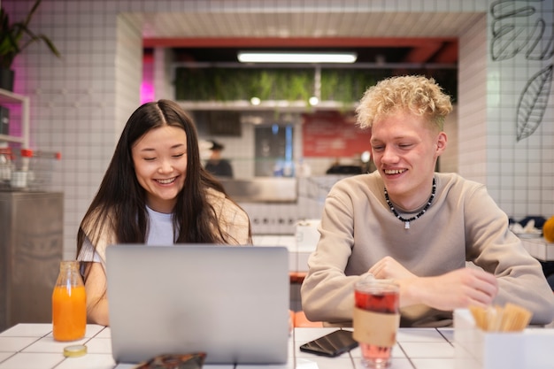 Medium shot smiley teenagers with laptop