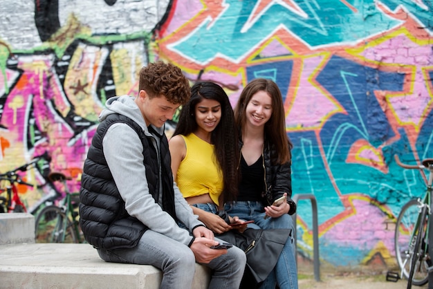 Medium shot smiley teens with phones