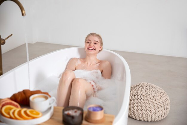 Medium shot smiley woman in bathtub