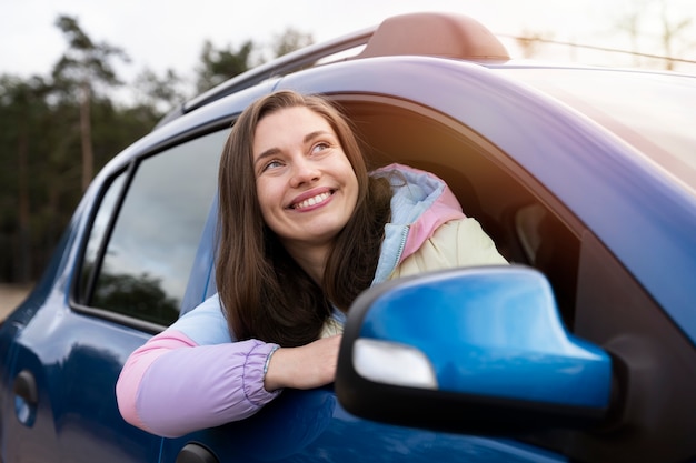 Medium shot smiley woman in car