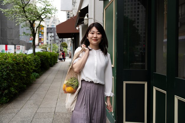 Medium shot smiley woman carrying tote bag