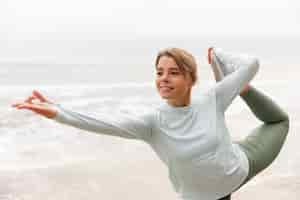 Free photo medium shot smiley woman doing yoga