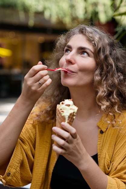 Medium shot smiley woman eating ice cream