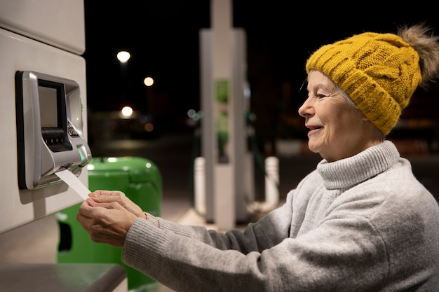 Free photo medium shot smiley woman at gas station