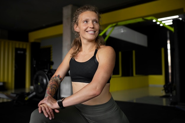 Medium shot smiley woman at gym