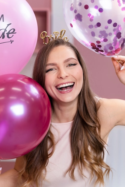 Medium shot smiley woman holding balloons