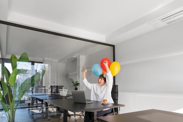 Medium shot smiley woman holding balloons