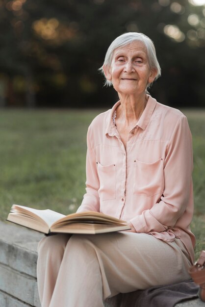 Medium shot smiley woman holding book