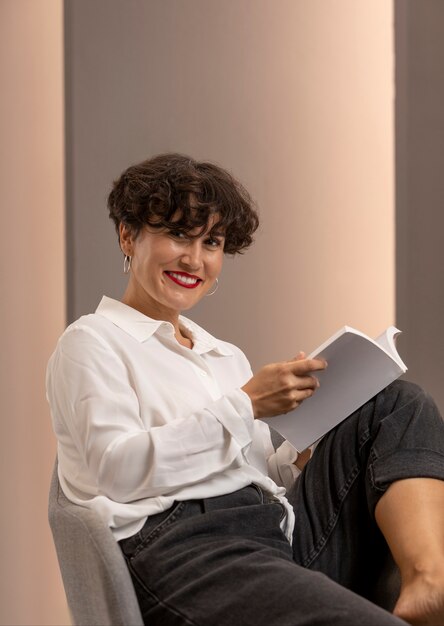 Medium shot smiley woman holding book