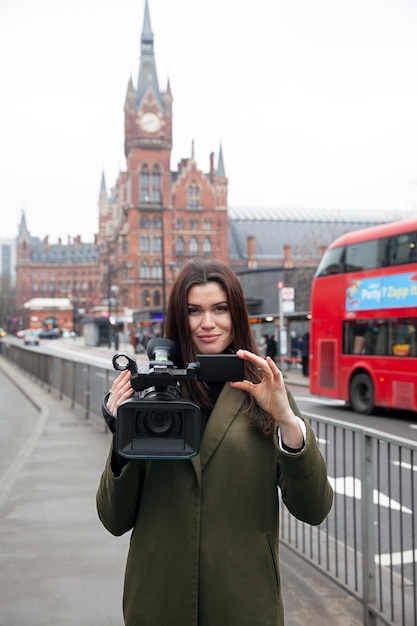 Medium shot smiley woman holding camera