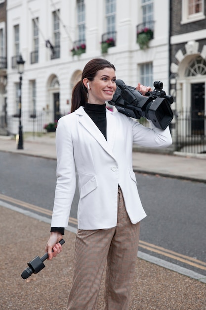 Free photo medium shot smiley woman holding camera