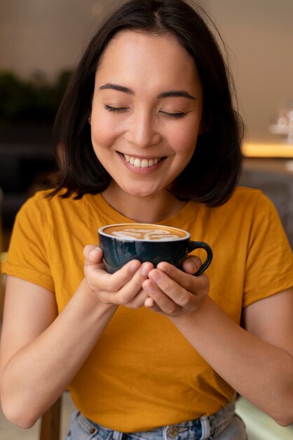 Medium shot smiley woman holding coffee cup