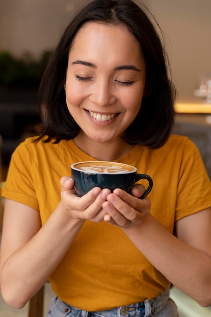 Medium shot smiley woman holding coffee cup