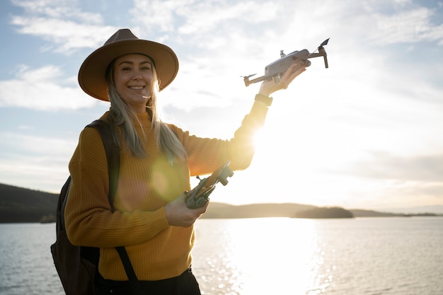 Medium shot smiley woman holding drone outdoors