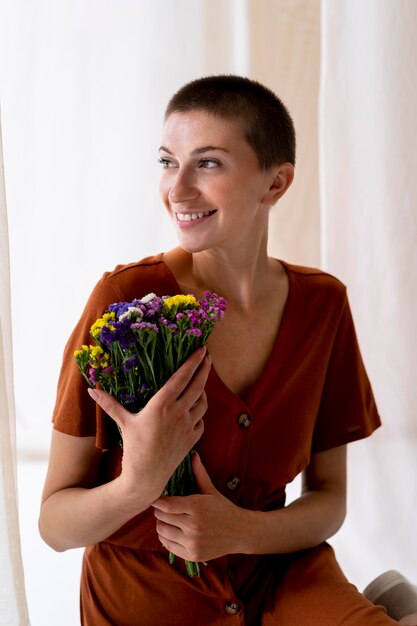 Medium shot smiley woman holding flowers