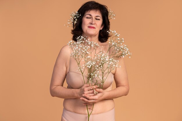 Medium shot smiley woman holding flowers