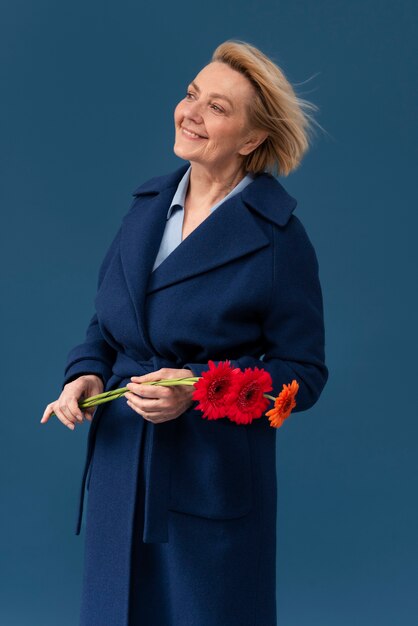 Medium shot smiley woman holding flowers