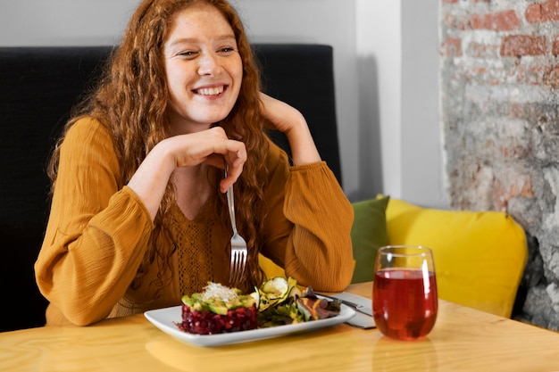 Free Photo medium shot smiley woman holding fork