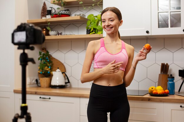 Medium shot smiley woman holding fruit