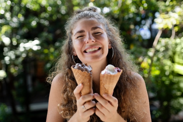 Free photo medium shot smiley woman holding ice creams