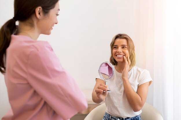 Medium shot smiley woman holding mirror