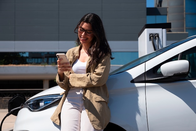 Free Photo medium shot smiley woman holding smartphone