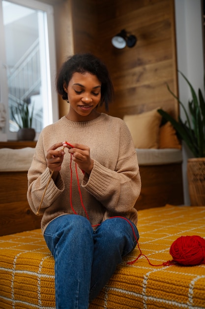 Medium shot smiley woman knitting