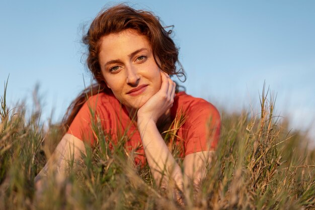 Medium shot smiley woman laying on ground