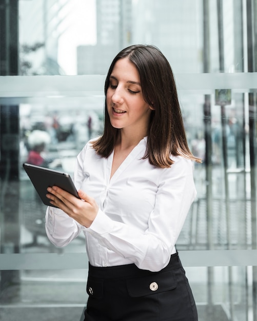 Free Photo medium shot smiley woman looking at her tablet 