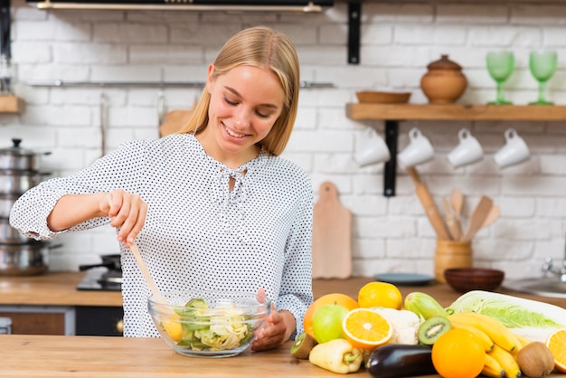 Free Photo medium shot smiley woman making a salad