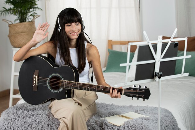 Medium shot smiley woman playing the guitar