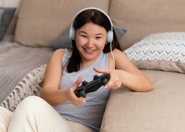 Medium shot smiley woman playing videogame