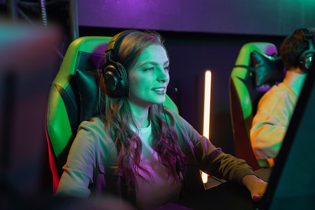 Free Photo medium shot smiley woman playing videogame