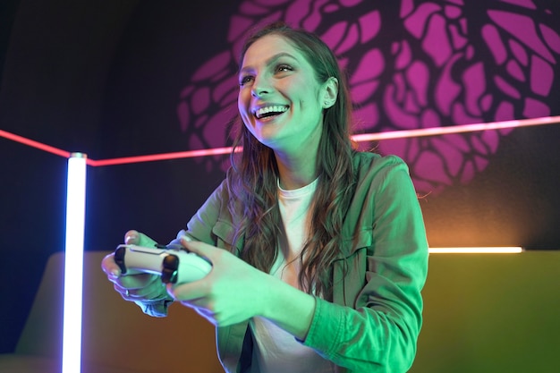 Free Photo medium shot smiley woman playing videogame