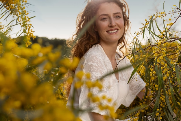 Free photo medium shot smiley woman posing with steppe flower