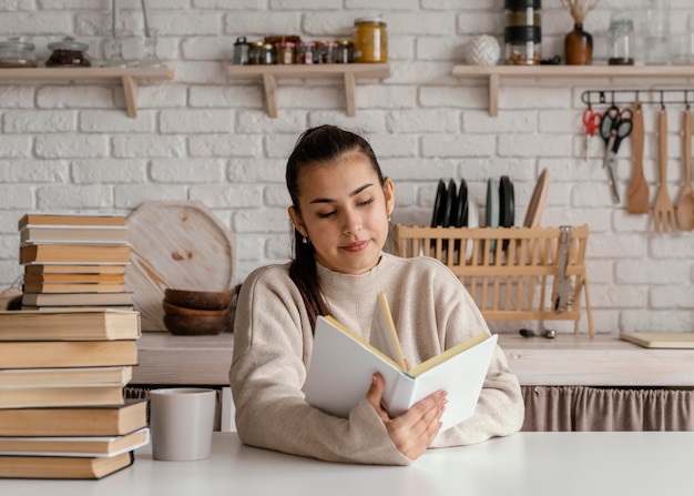 Medium shot smiley woman reading indoors