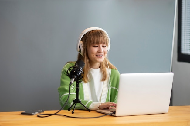 Medium shot smiley woman recording podcast