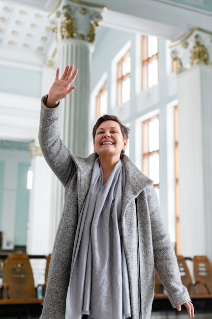 Medium shot smiley woman saluting