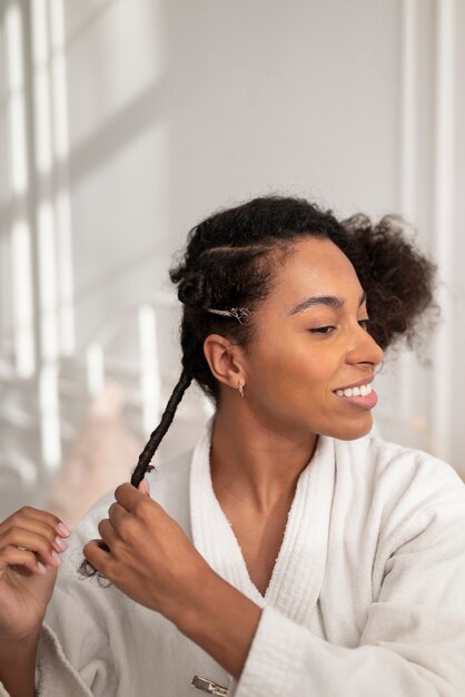 Medium shot smiley woman styling hair