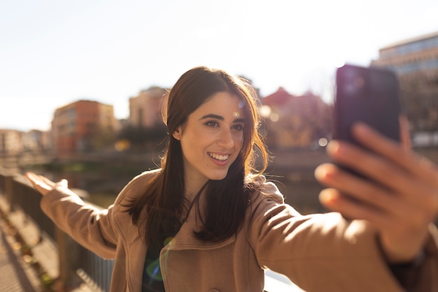 Medium shot smiley woman taking selfie